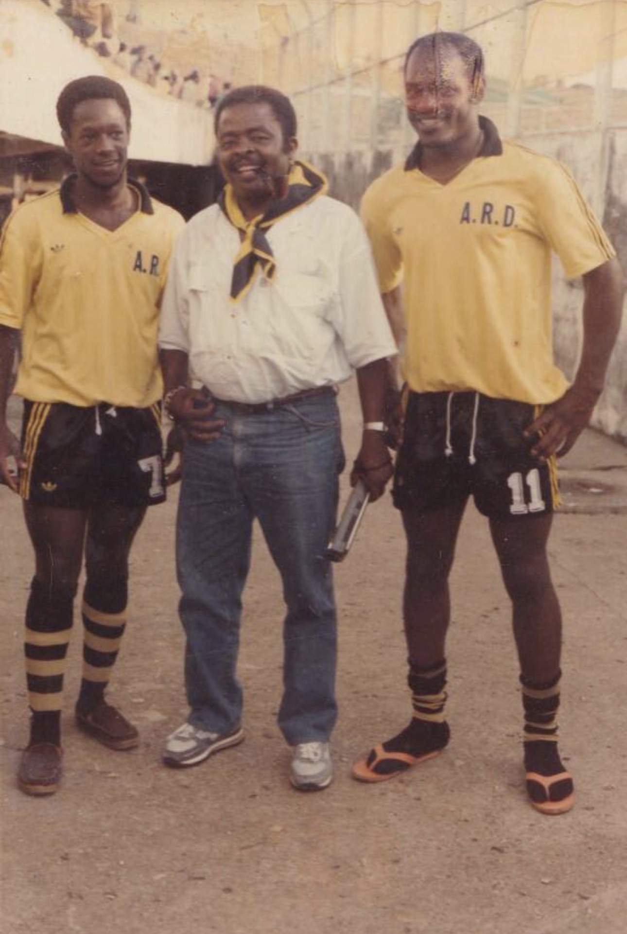 Souvenir de Paul Roger Tsobgni dit Kopa - Paul Roger Tsobny Kopa Standing With Two Ard Football Teammates Wearing Yellow Football Jerseys Before Match Historic Cameroon Football Photo